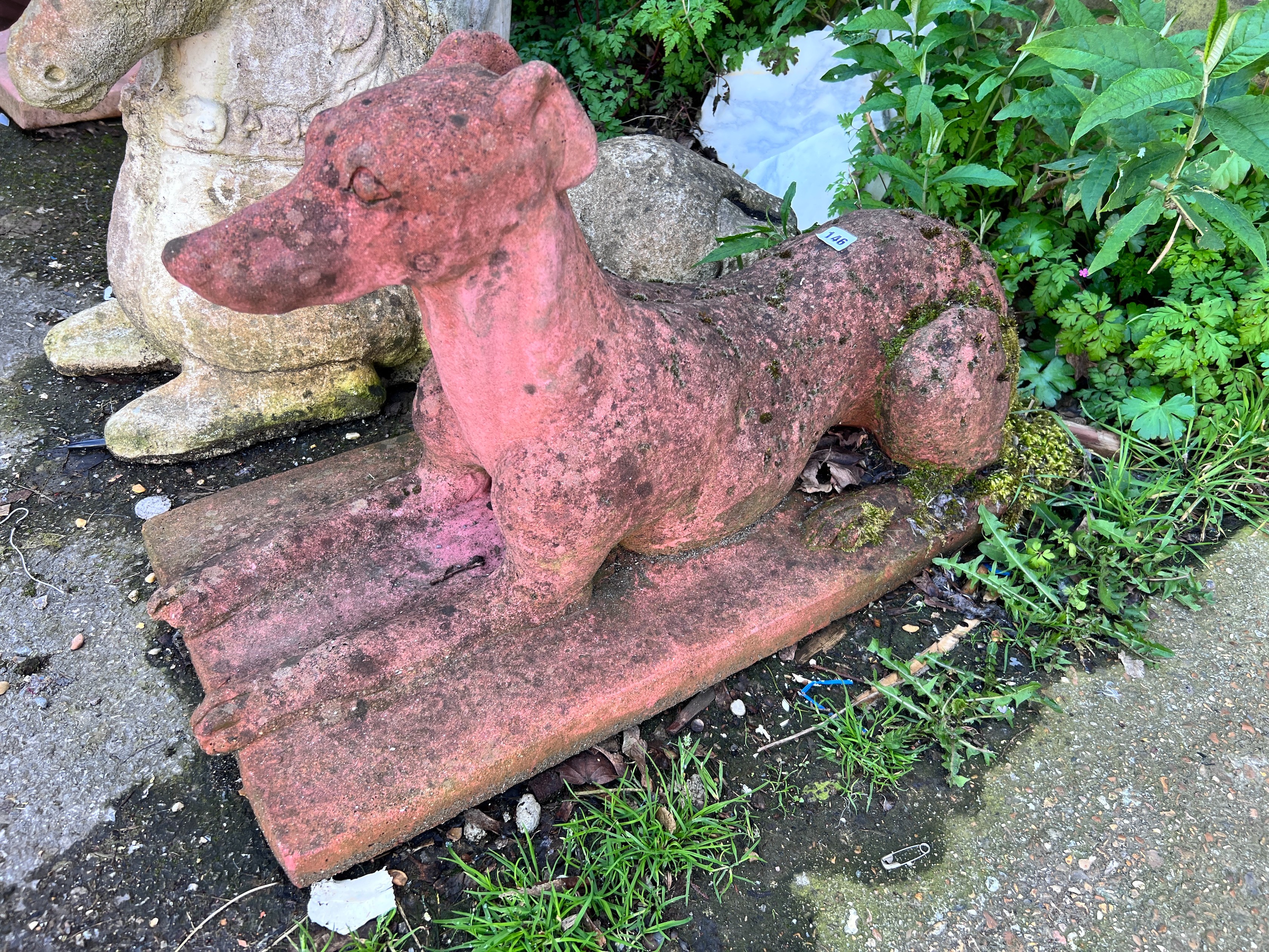 A terracotta recumbent greyhound garden ornament, height 40cm *Please note the sale commences at 9am.
